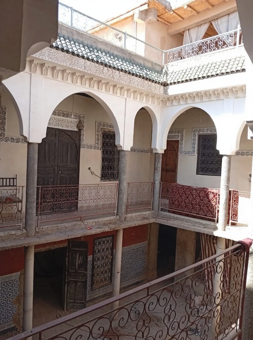 Moroccan guesthouse courtyard in Michouar with arches and traditional design.