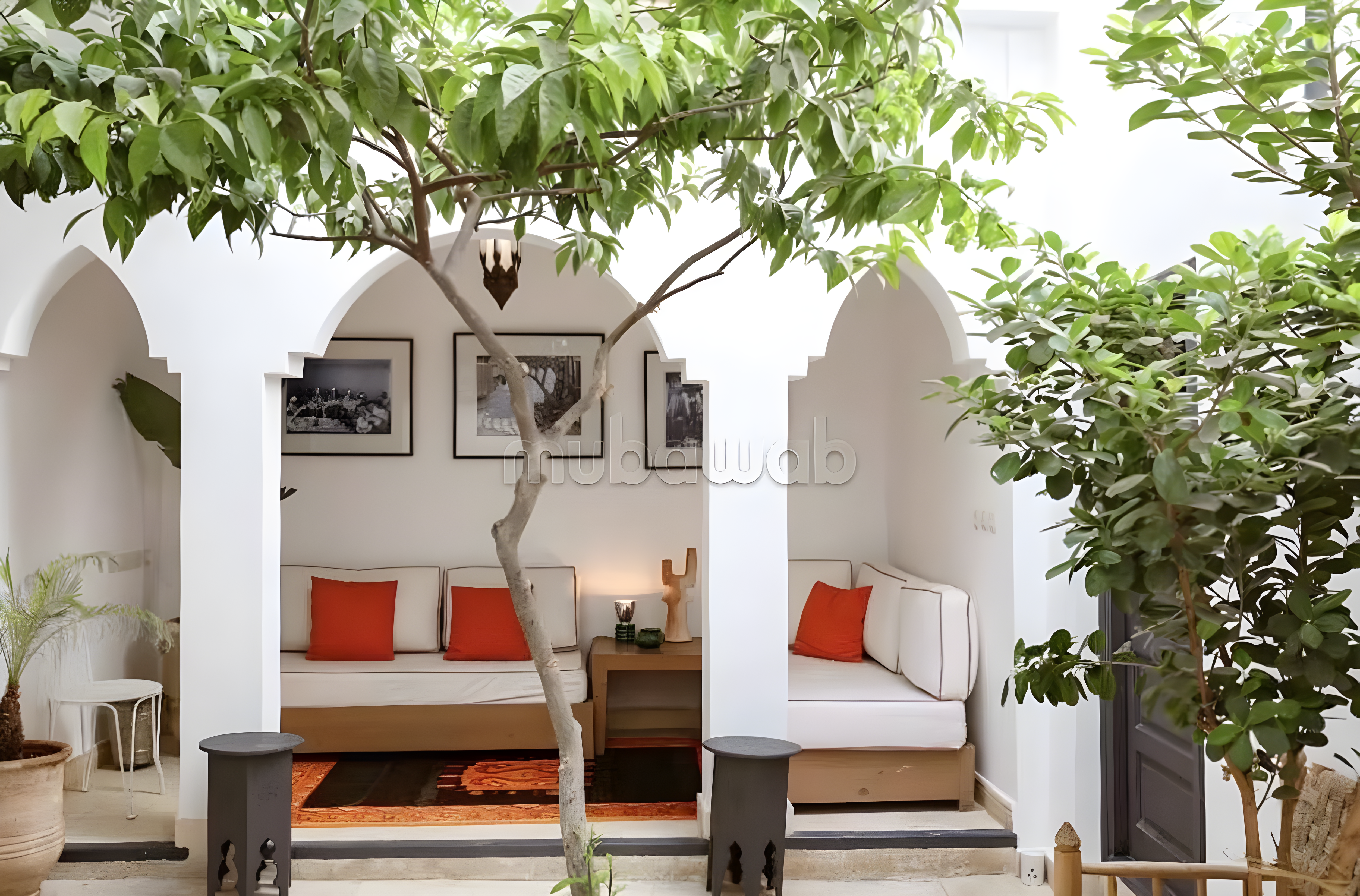 Elegant patio with archways, lush greenery, and central tree in Arset Ben Chebli guesthouse.