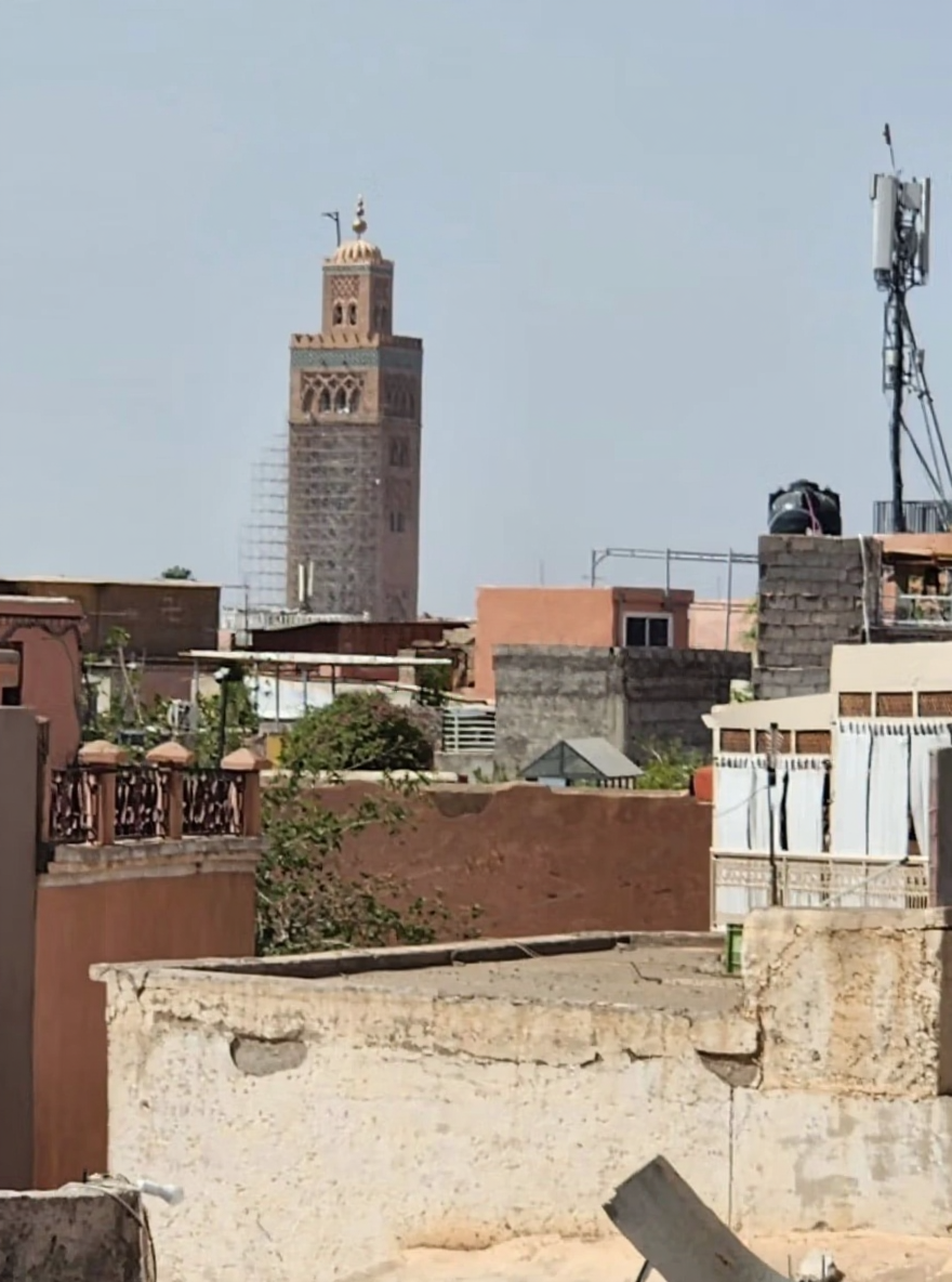 Rooftop view of a guesthouse in Arset El Maach with Koutoubia Mosque in the distance.