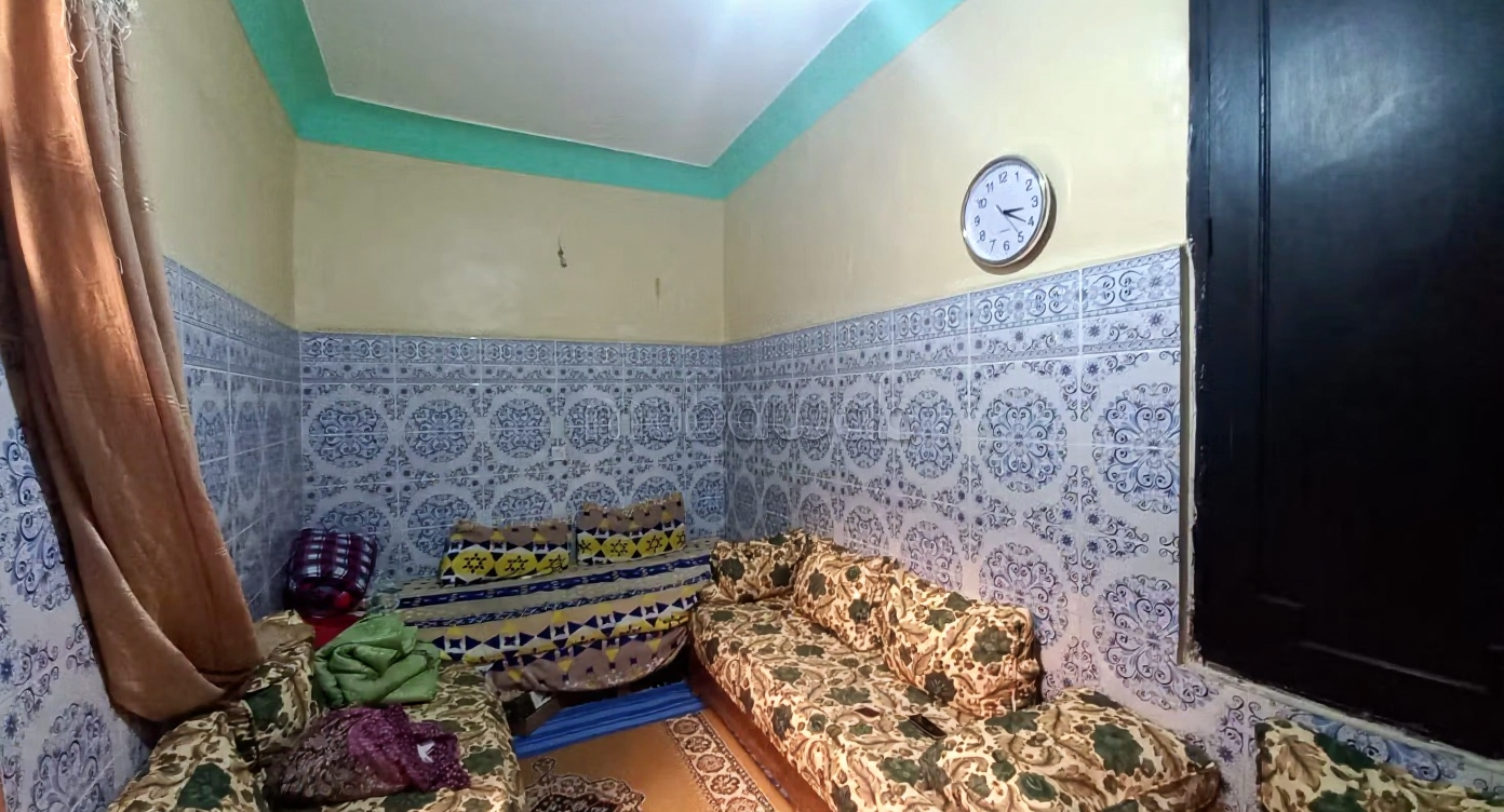 Traditional Moroccan salon with tiled walls and upholstered seating in Riad Zitoun.