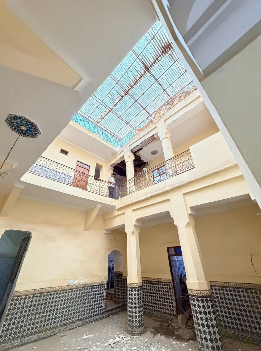 Moroccan riad courtyard with tiled walls and skylight in Essebtiyen guesthouse.