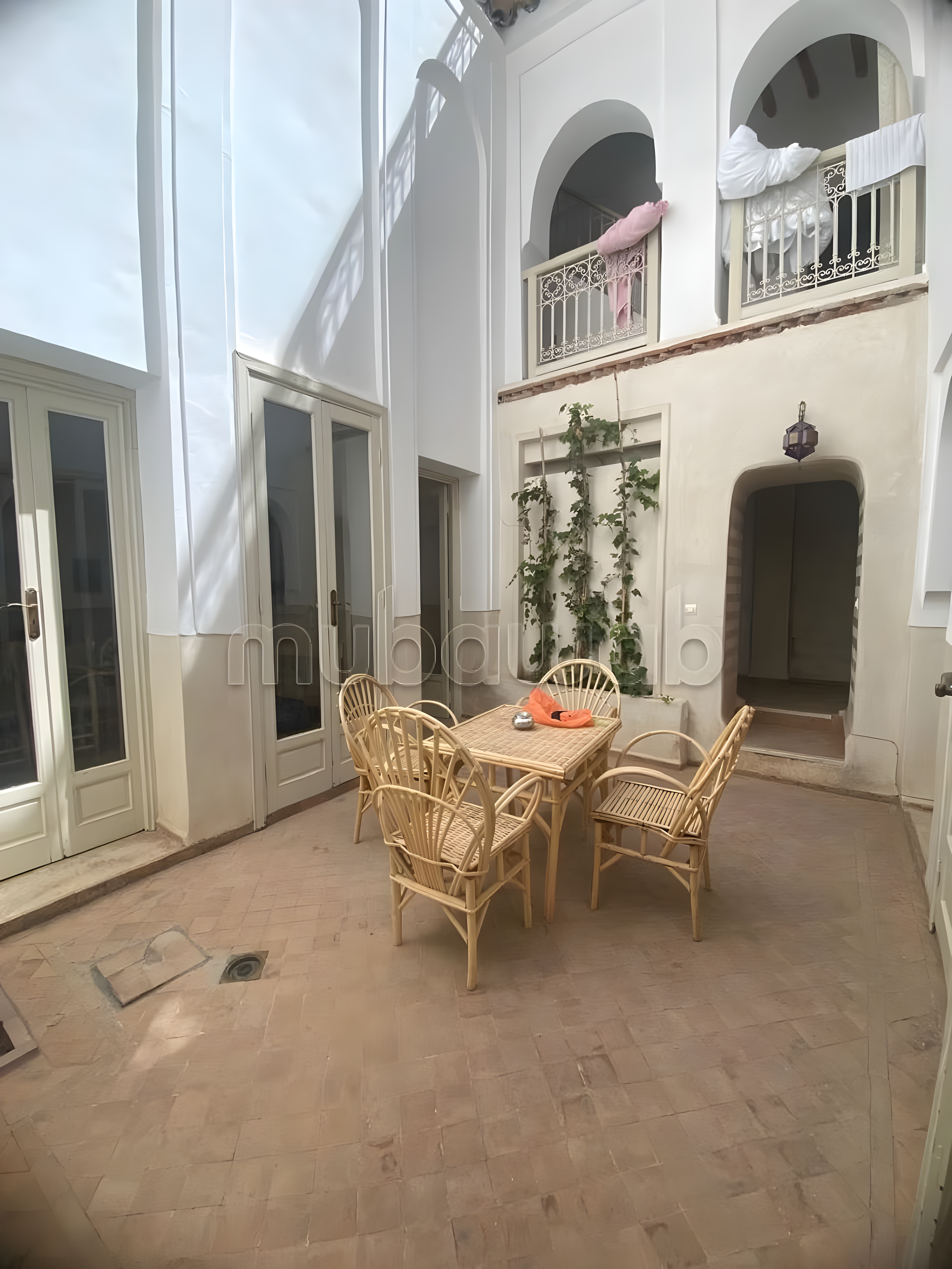 Bright courtyard with wicker furniture in a Kennaria guesthouse.