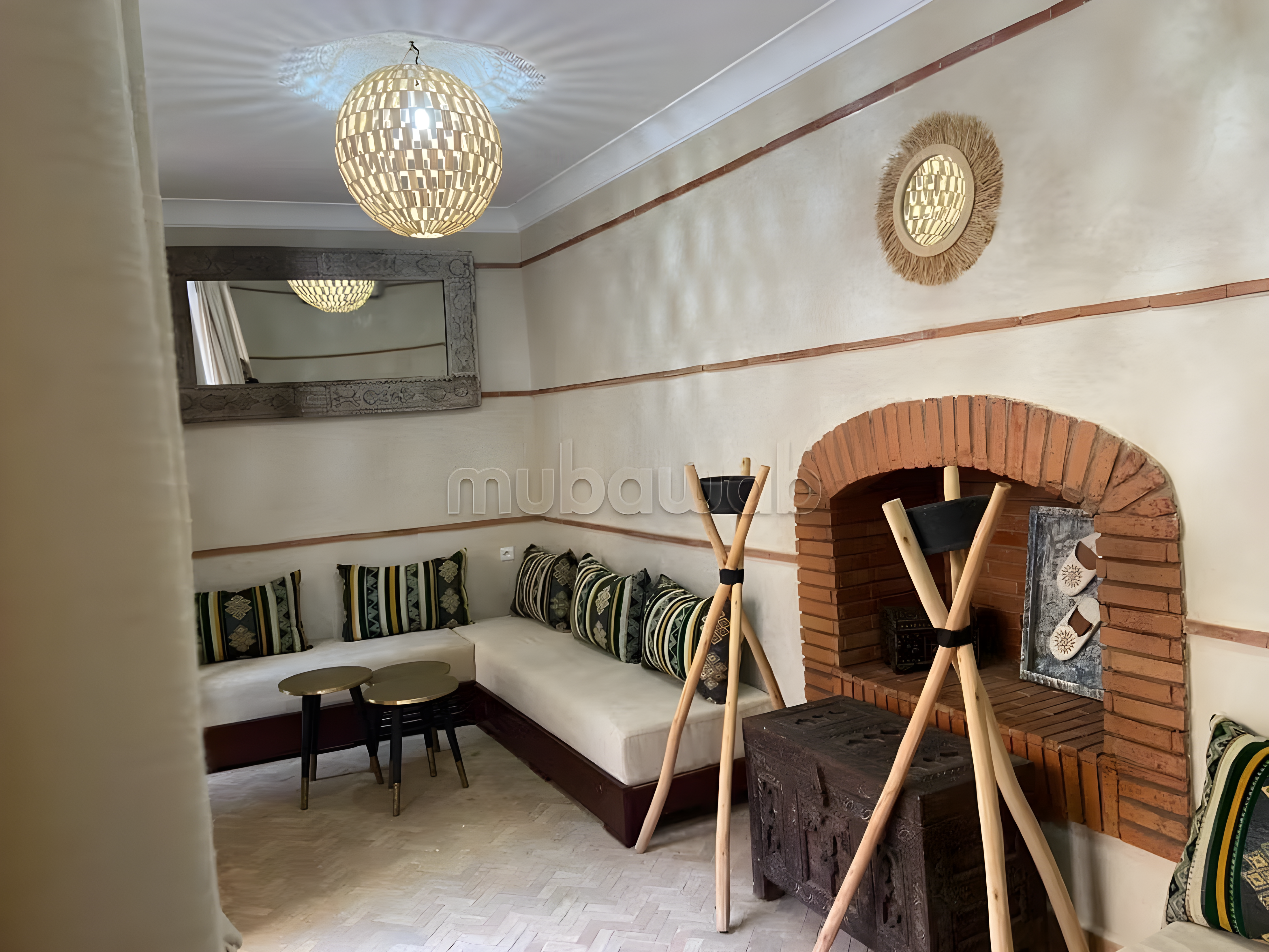 Moroccan salon with built-in seating, patterned cushions, fireplace, and lighting.