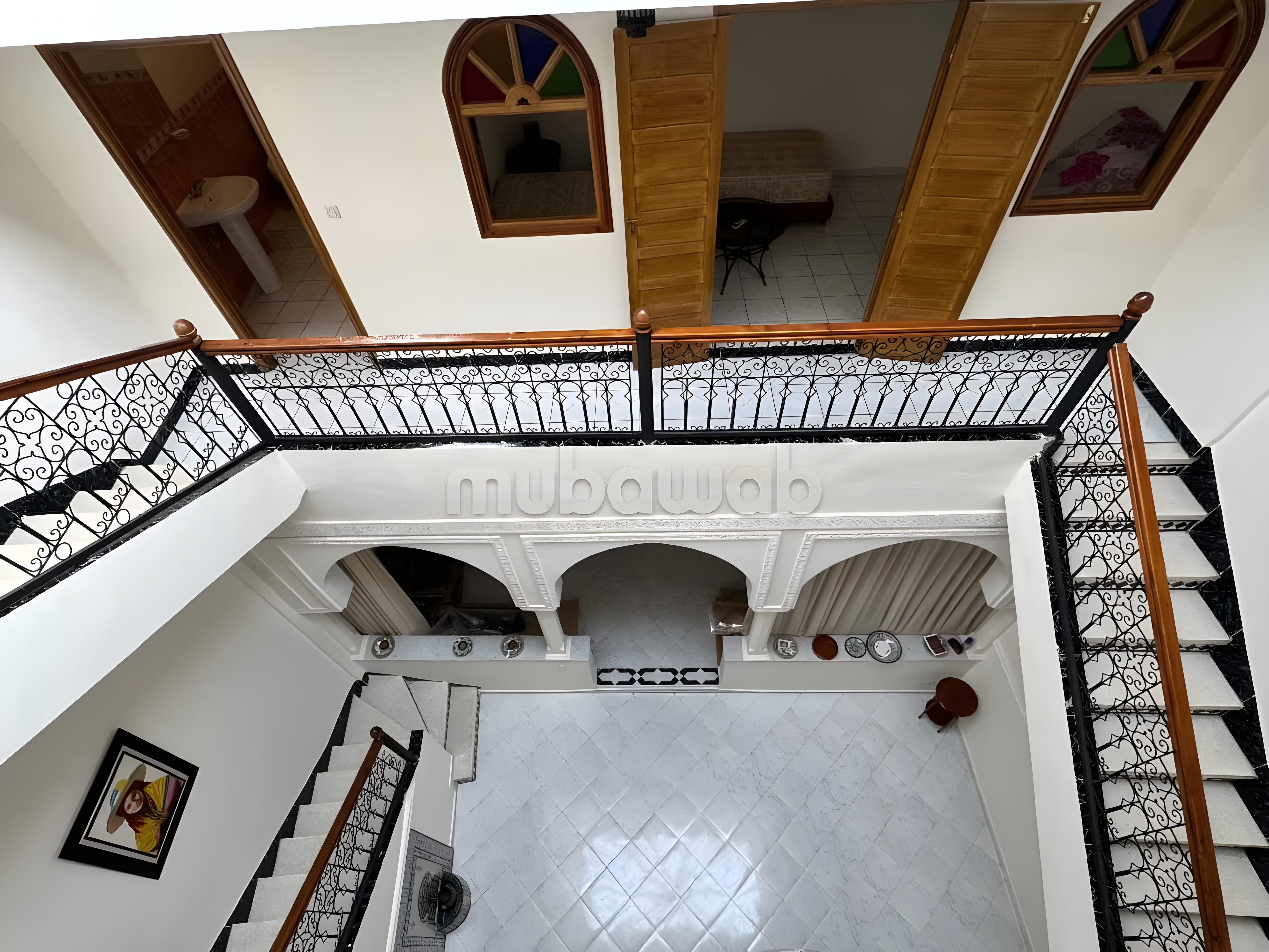 Moroccan riad courtyard in Kechich with tiled floor and decorative railings.