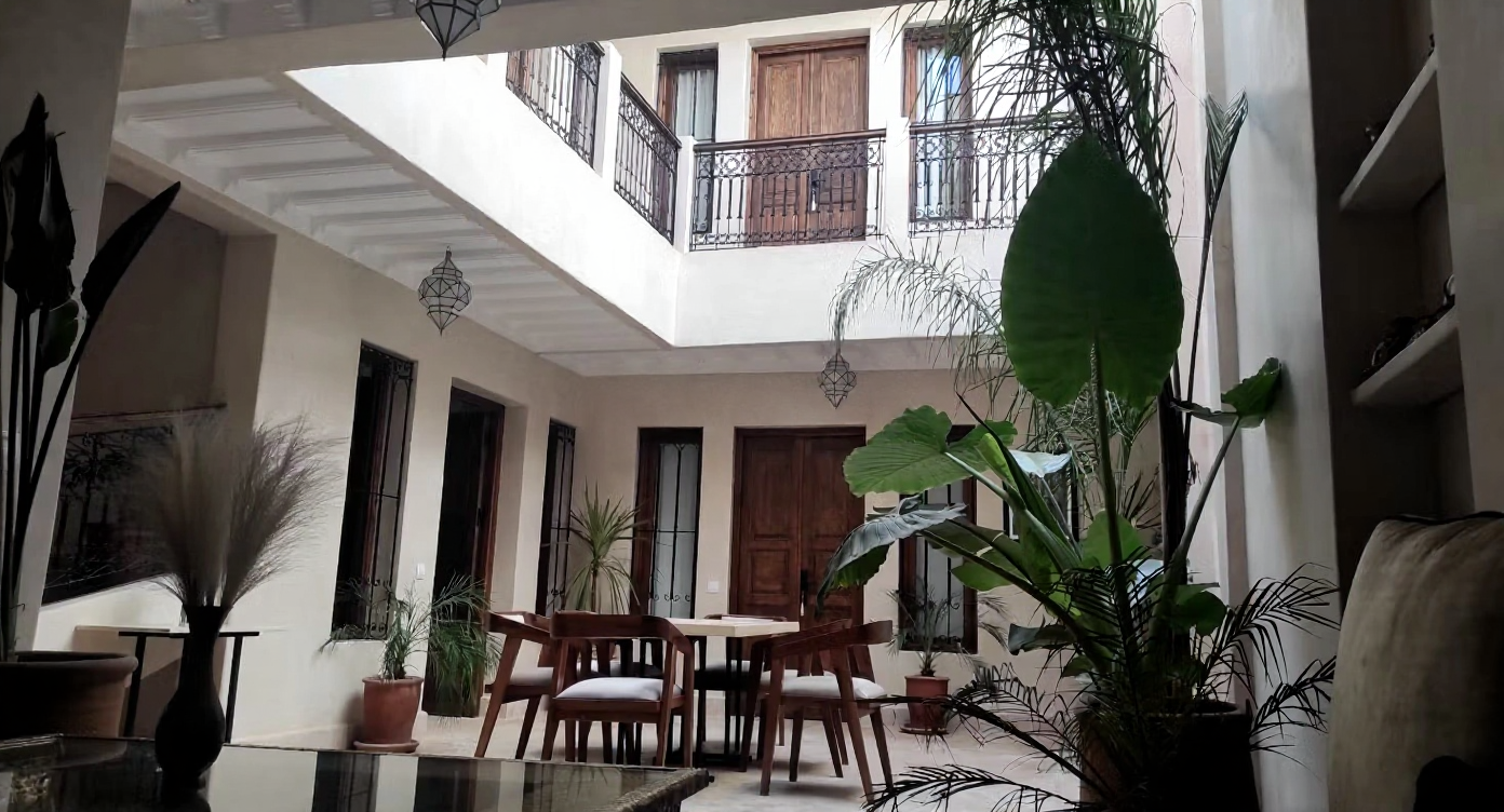 Courtyard in Arset El Houta guesthouse with dining area and plants.