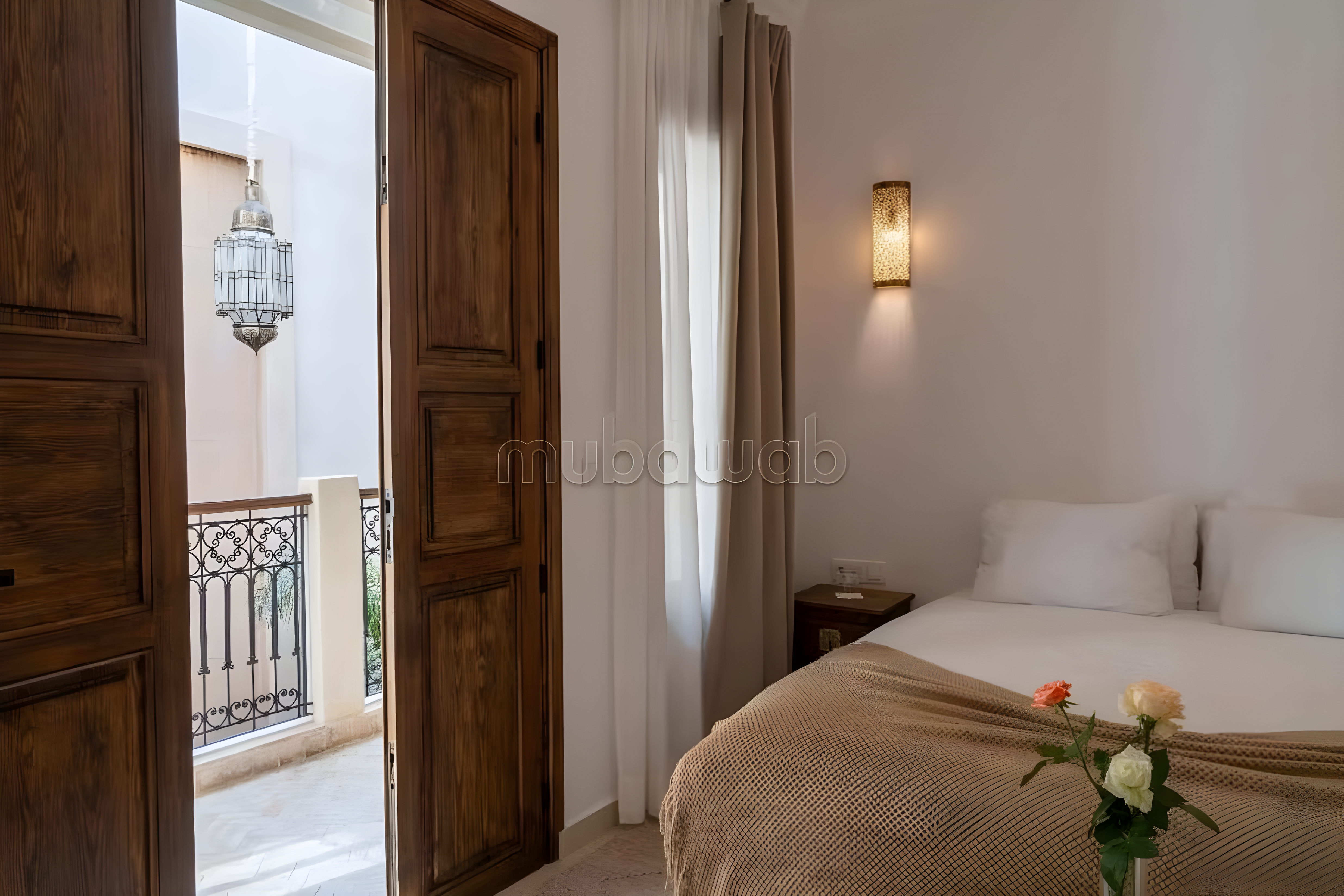 Guesthouse bedroom with wooden doors and balcony in Rmila.
