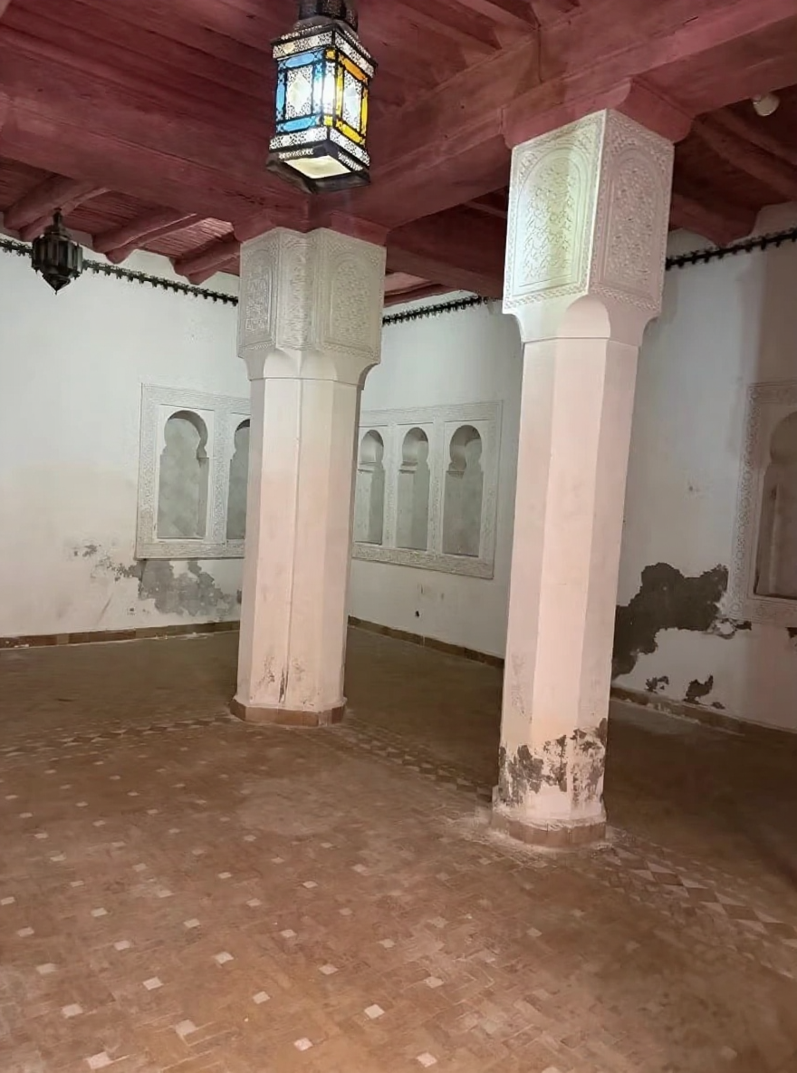 Traditional Moroccan salon with carved pillars and ceiling beams in Arset El Maach.