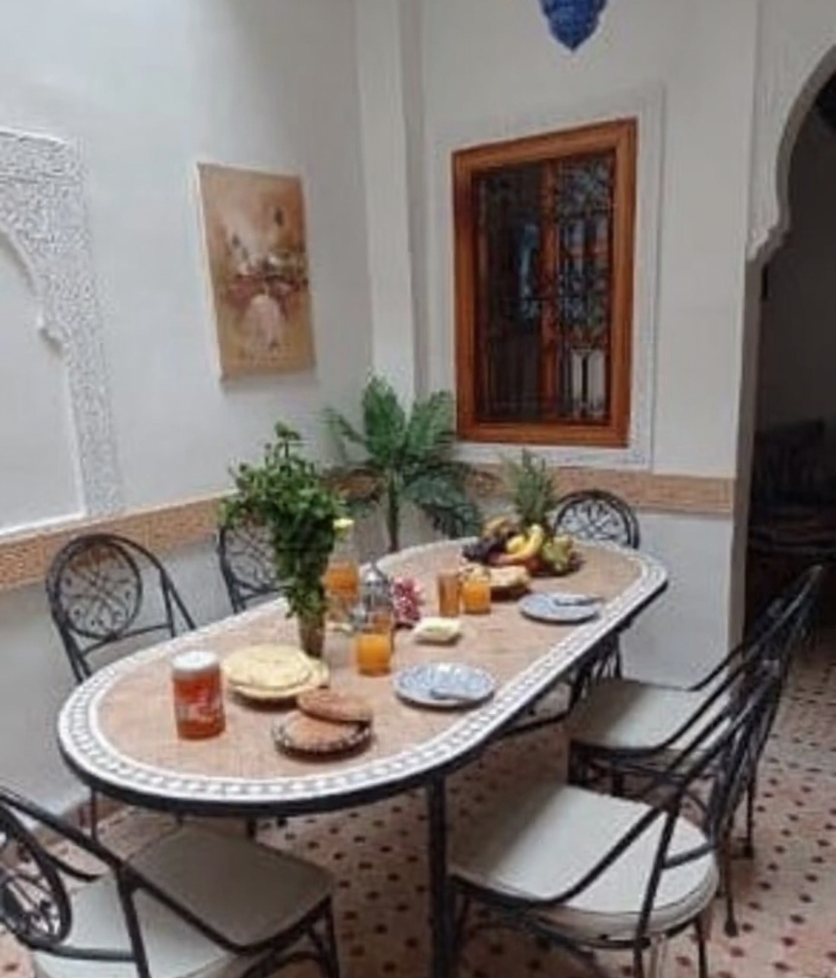 Moroccan patio in Mouassine with dining arrangement and traditional decor.