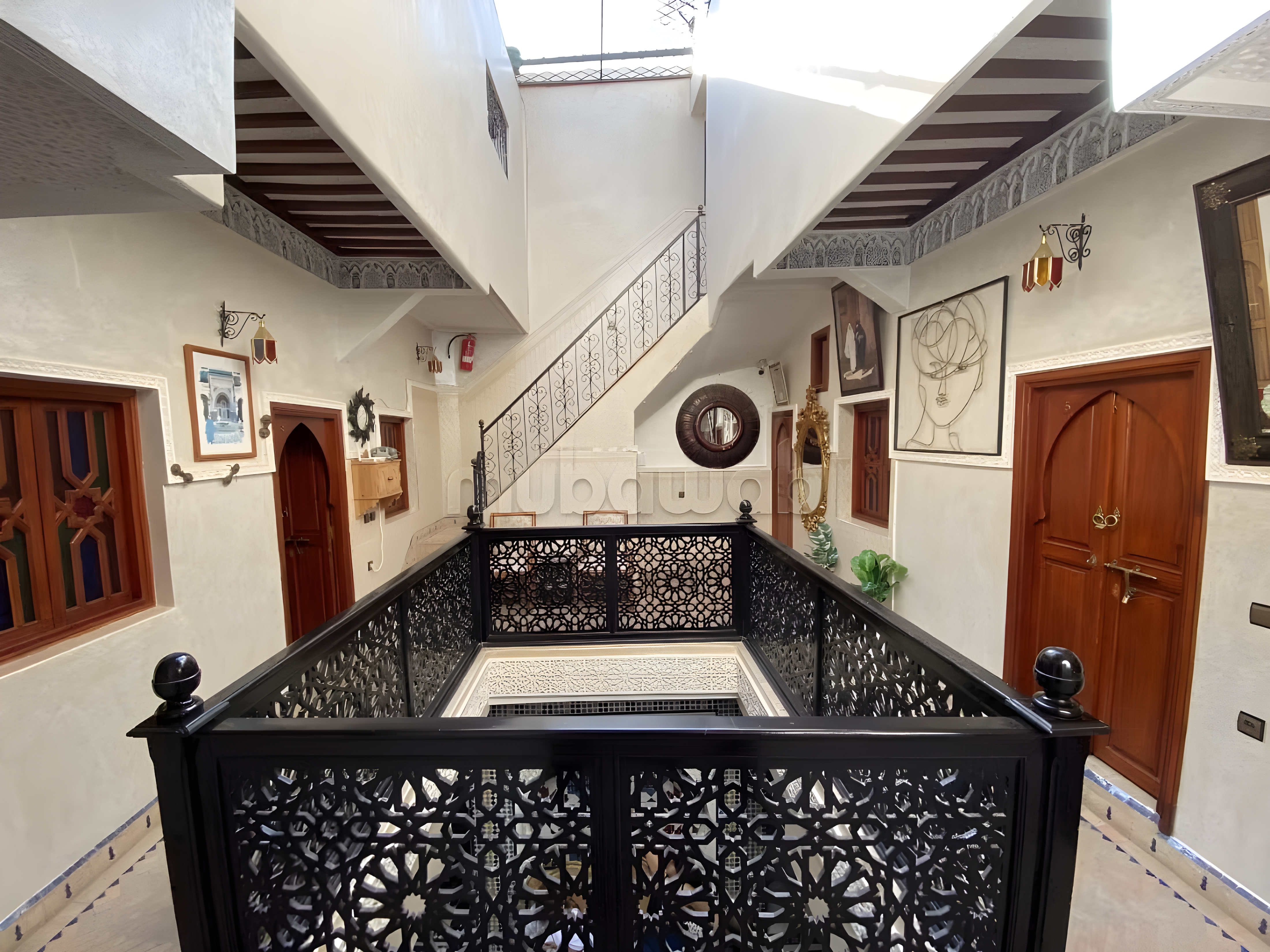 Enclosed courtyard in Sidi Bou Amar with ornate railing and Moroccan decor.