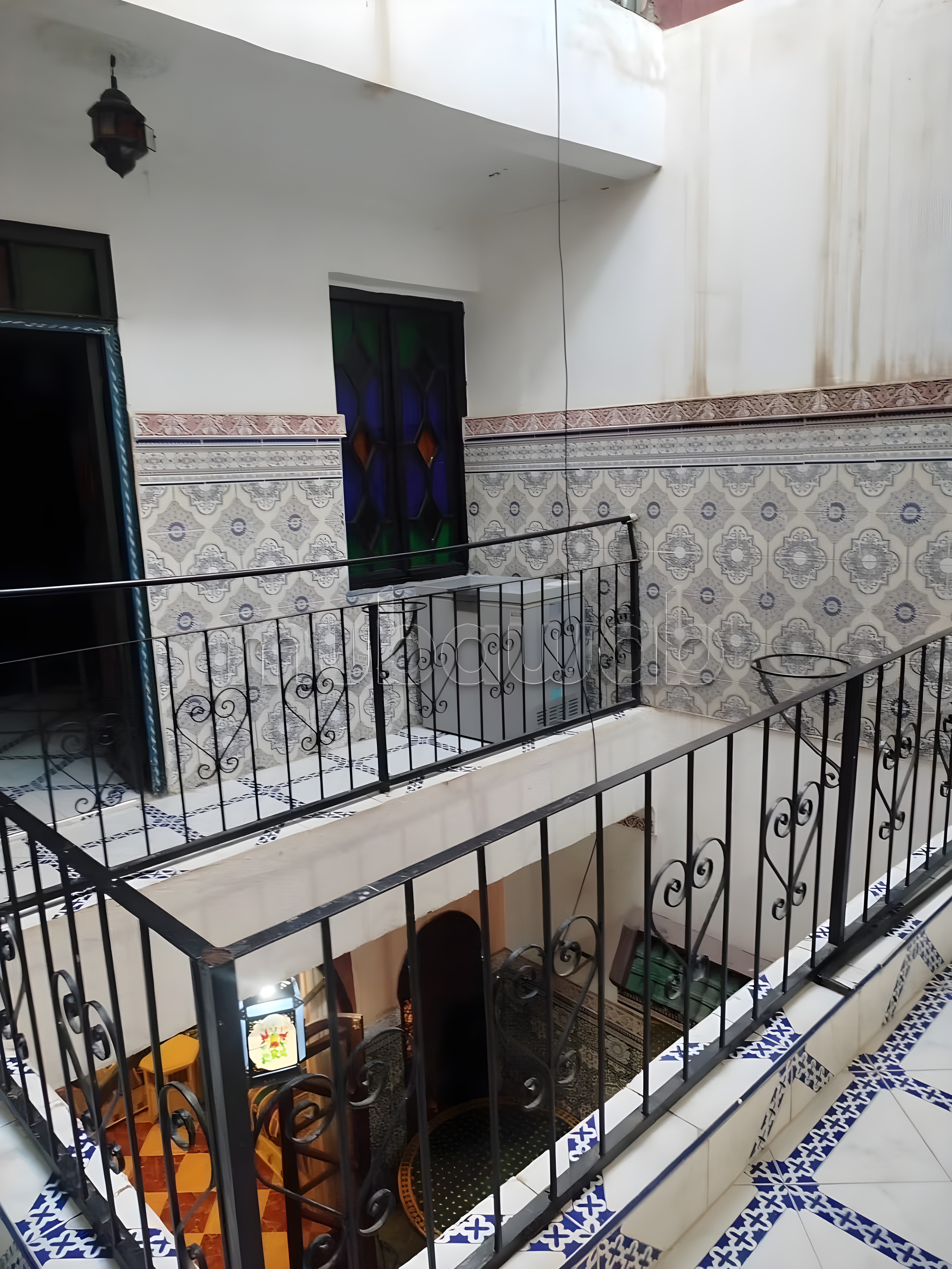 Moroccan staircase in Kaat Ben Nahid with tilework and stained glass accents.