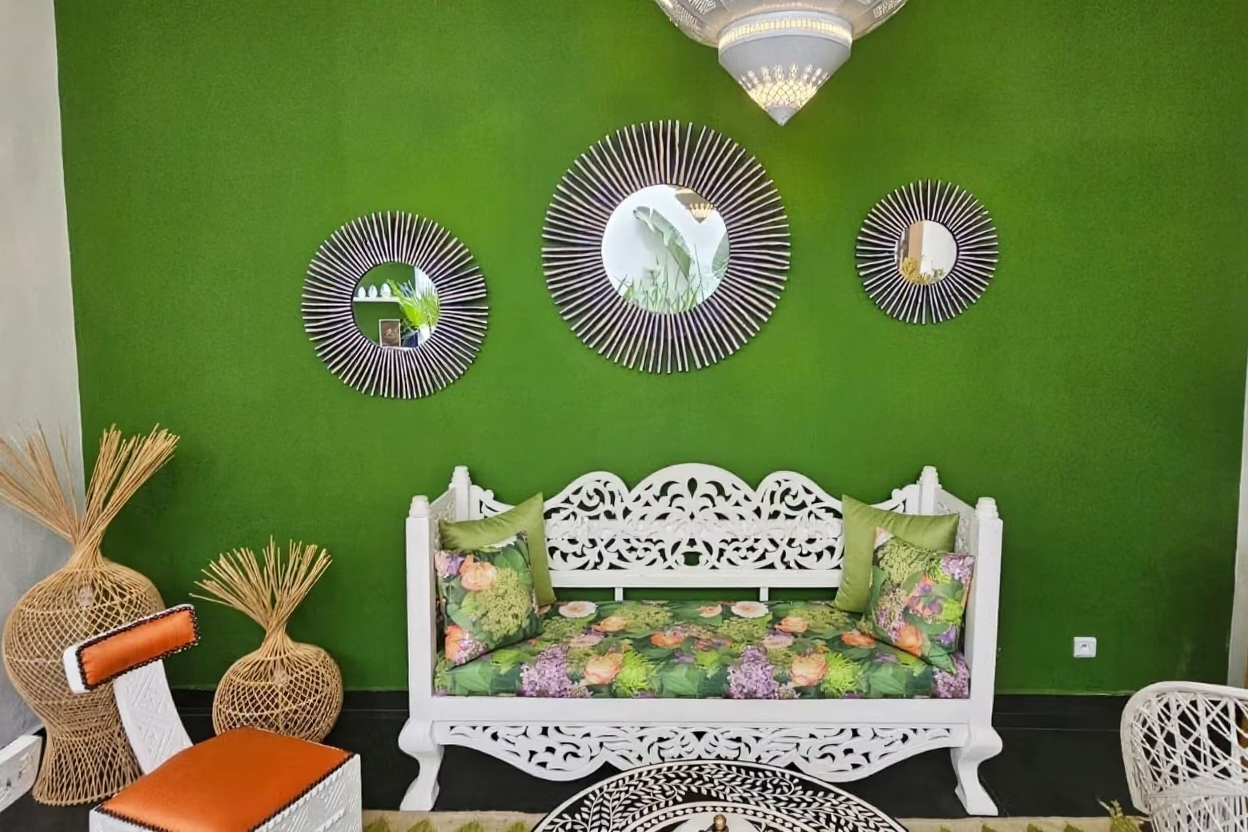 Salon in Bab Lhmar guesthouse with green walls and carved seating.