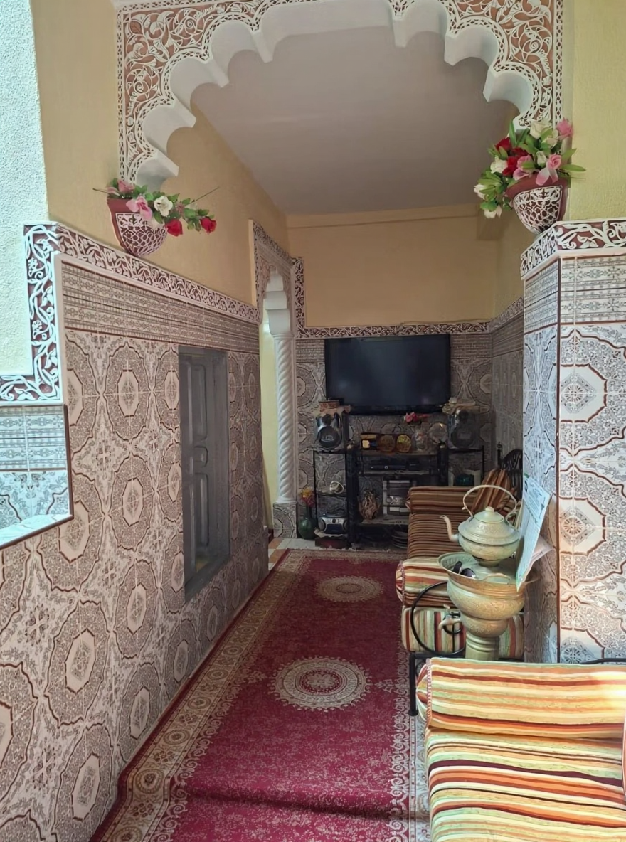 Moroccan salon in Rmila with patterned tiles and striped seating.