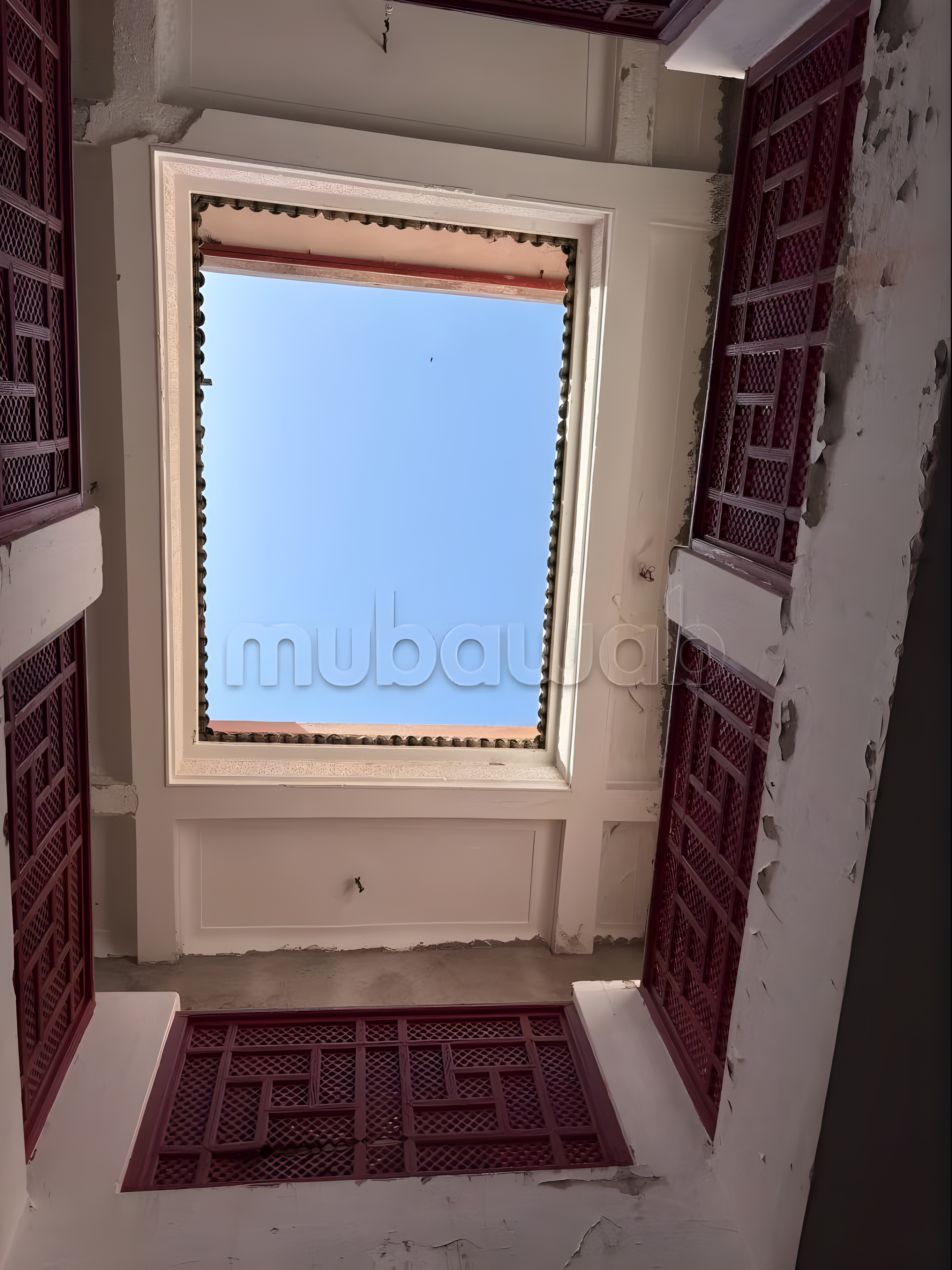 Moroccan courtyard with skylight and red shutters in Arset El Maach