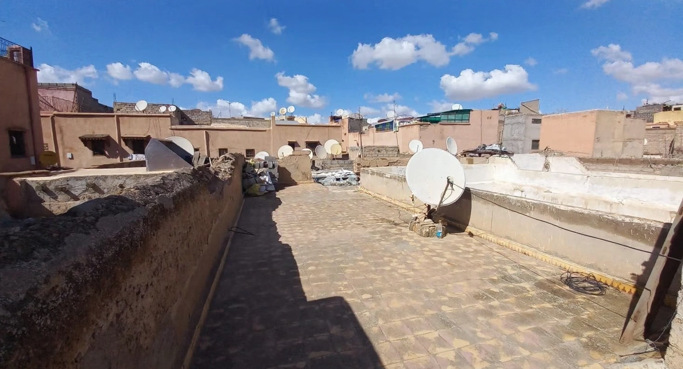 Flat rooftop with satellite dishes at a guesthouse in Ben Saleh, Morocco.