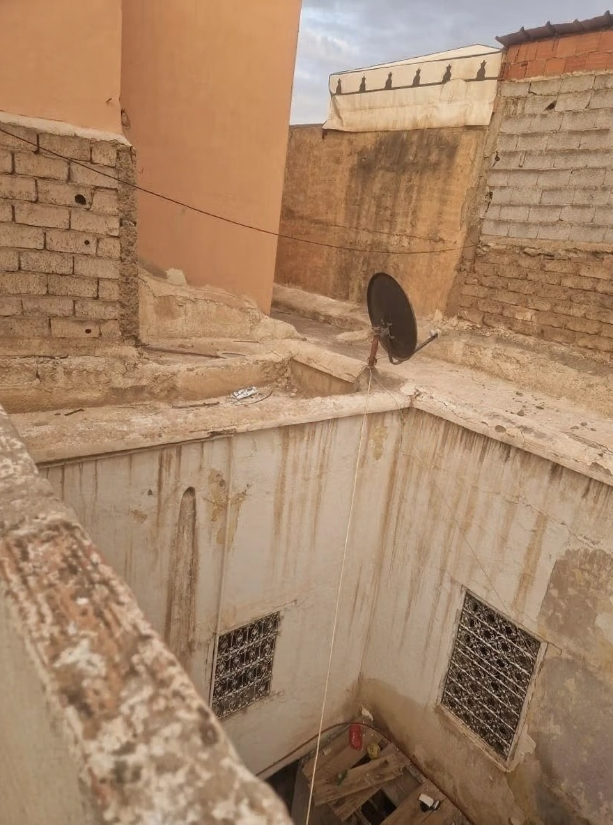 Rooftop view of a riad in Arset El Maach with walls and a satellite dish.
